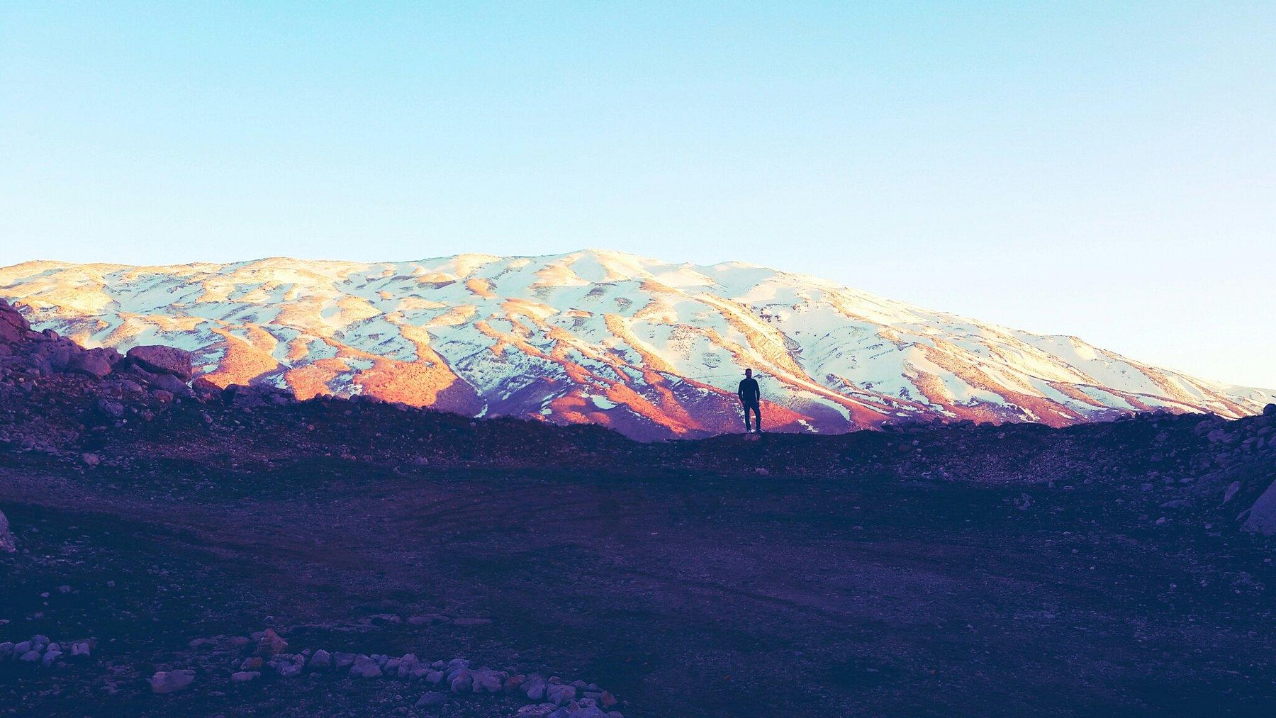 A breathtaking view of Mount Hermon, its snow-capped peaks standing tall over the diverse landscapes, rich in biodiversity and natural beauty.